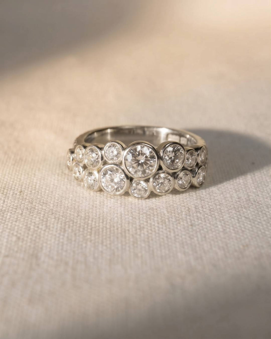 Platinum two-row diamond ring with bezel-set round diamonds.