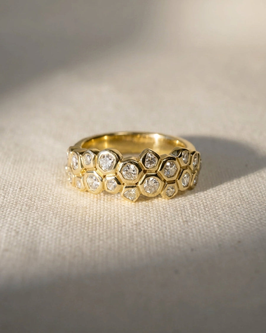 Gold eternity ring with carved small old cut diamonds in a honeycomb design.