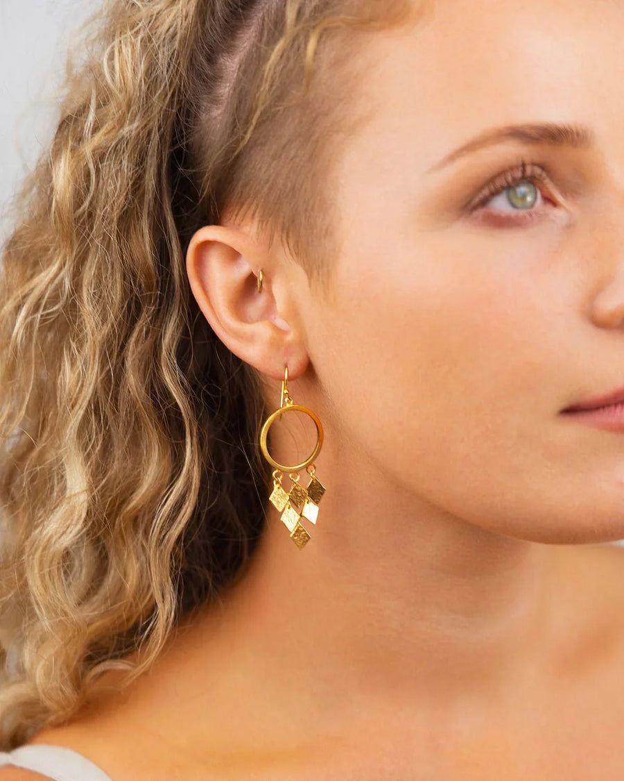 woman wearing handmade gold drop chandelier earrings with geometric dangles