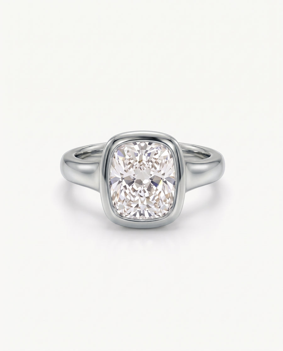 Cushion cut diamond engagement ring in a polished silver-tone bezel setting on a smooth metal band.