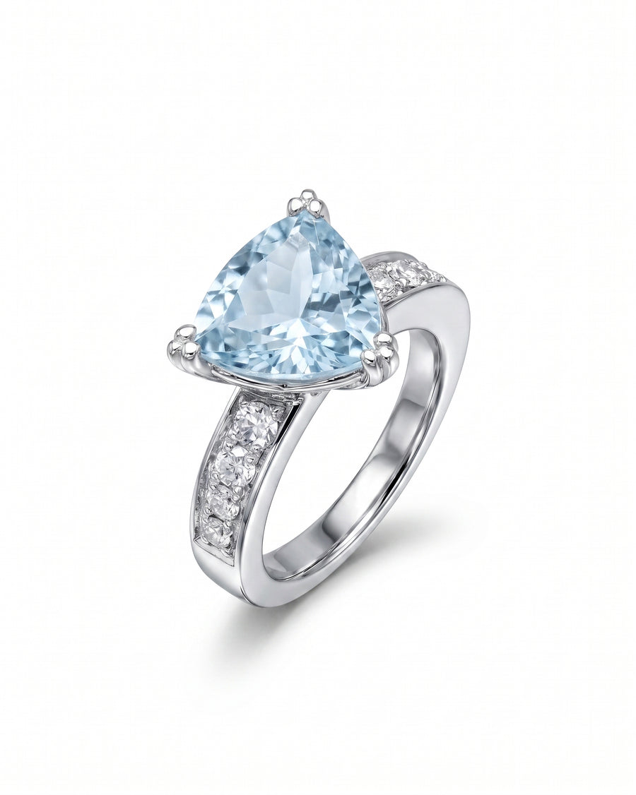Silver ring with a large trillion-cut blue gemstone and small clear side stones.