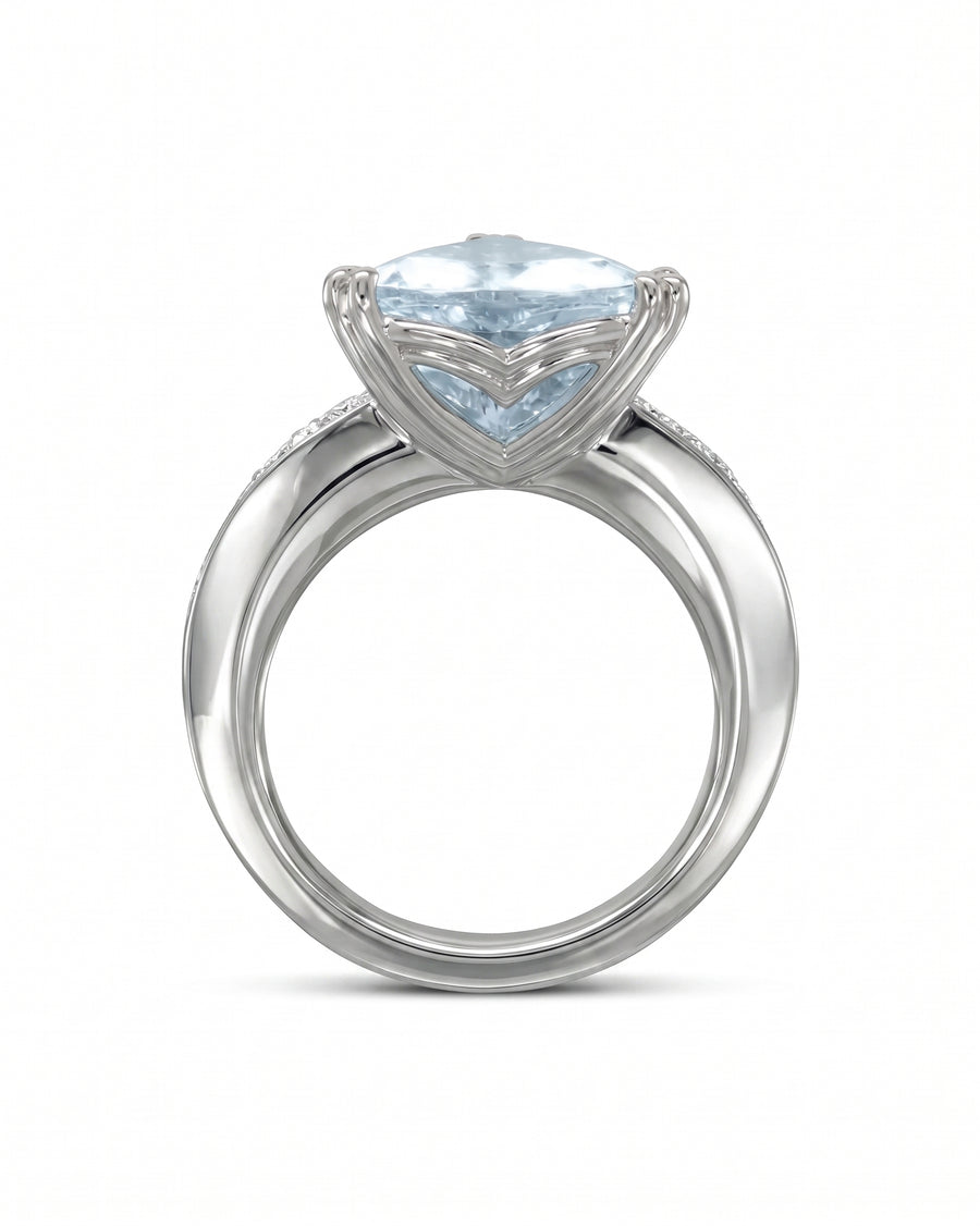 Silver solitaire engagement ring with a light blue cushion-cut gemstone and double claw prongs.