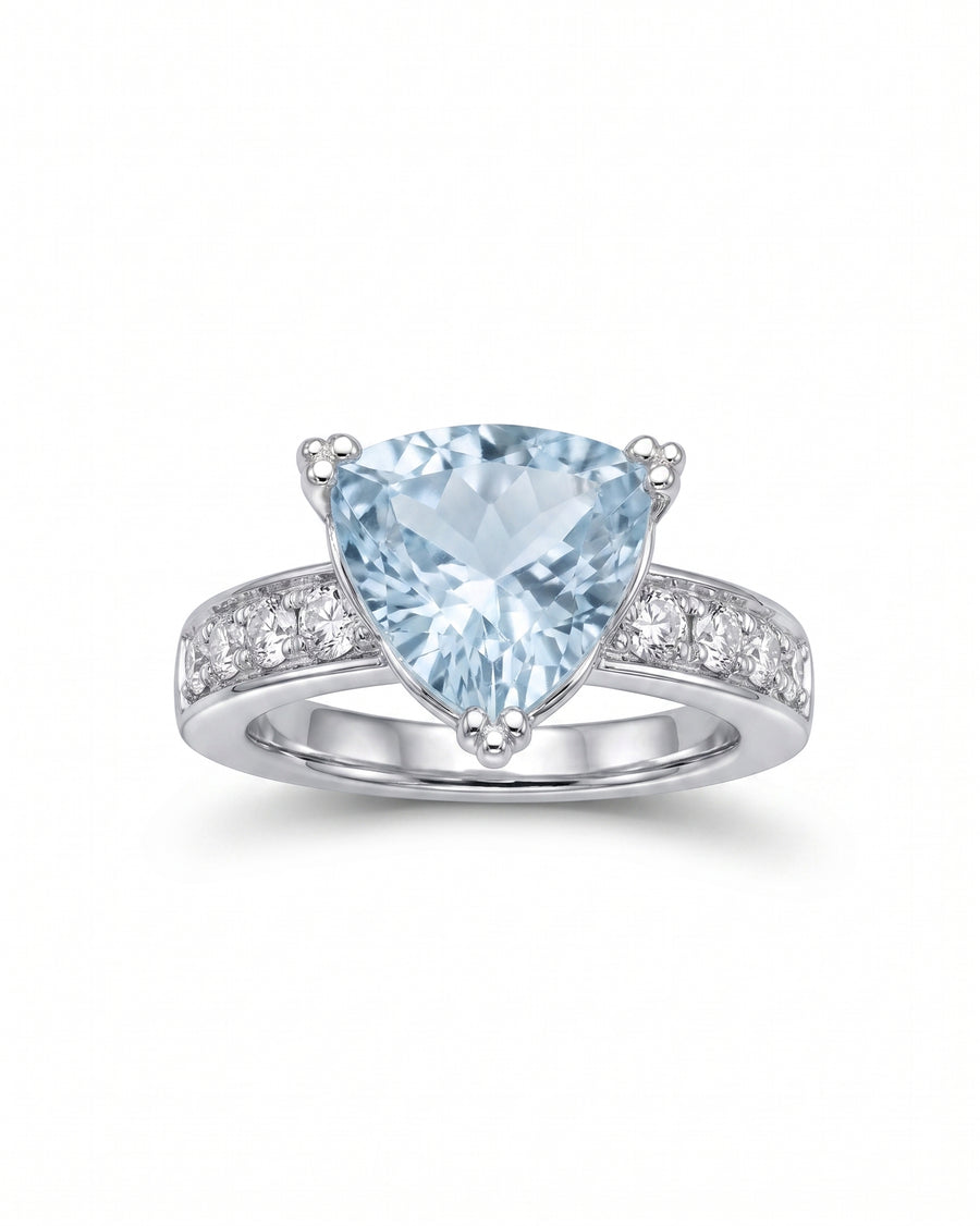 Silver ring with a large trillion-cut blue gemstone and pavé diamonds.