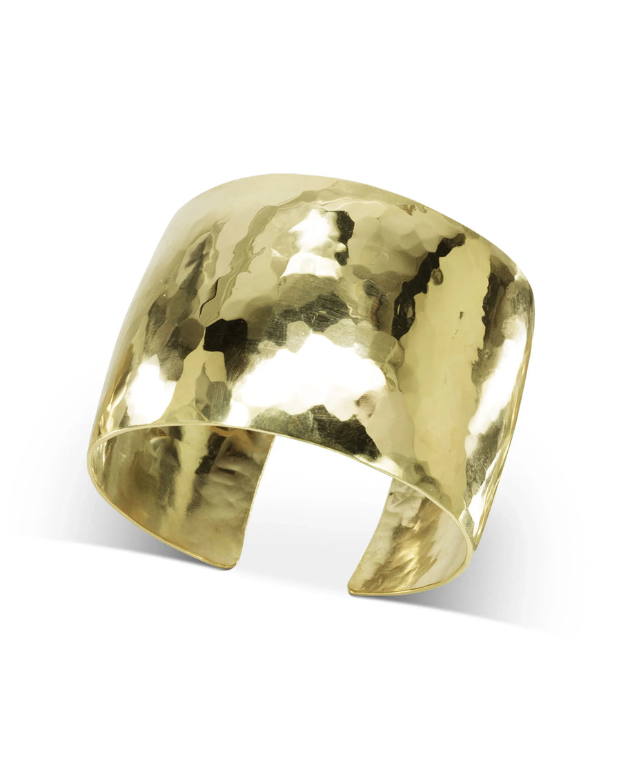 Wide hammered gold cuff bracelet with organic, textured finish on a white background