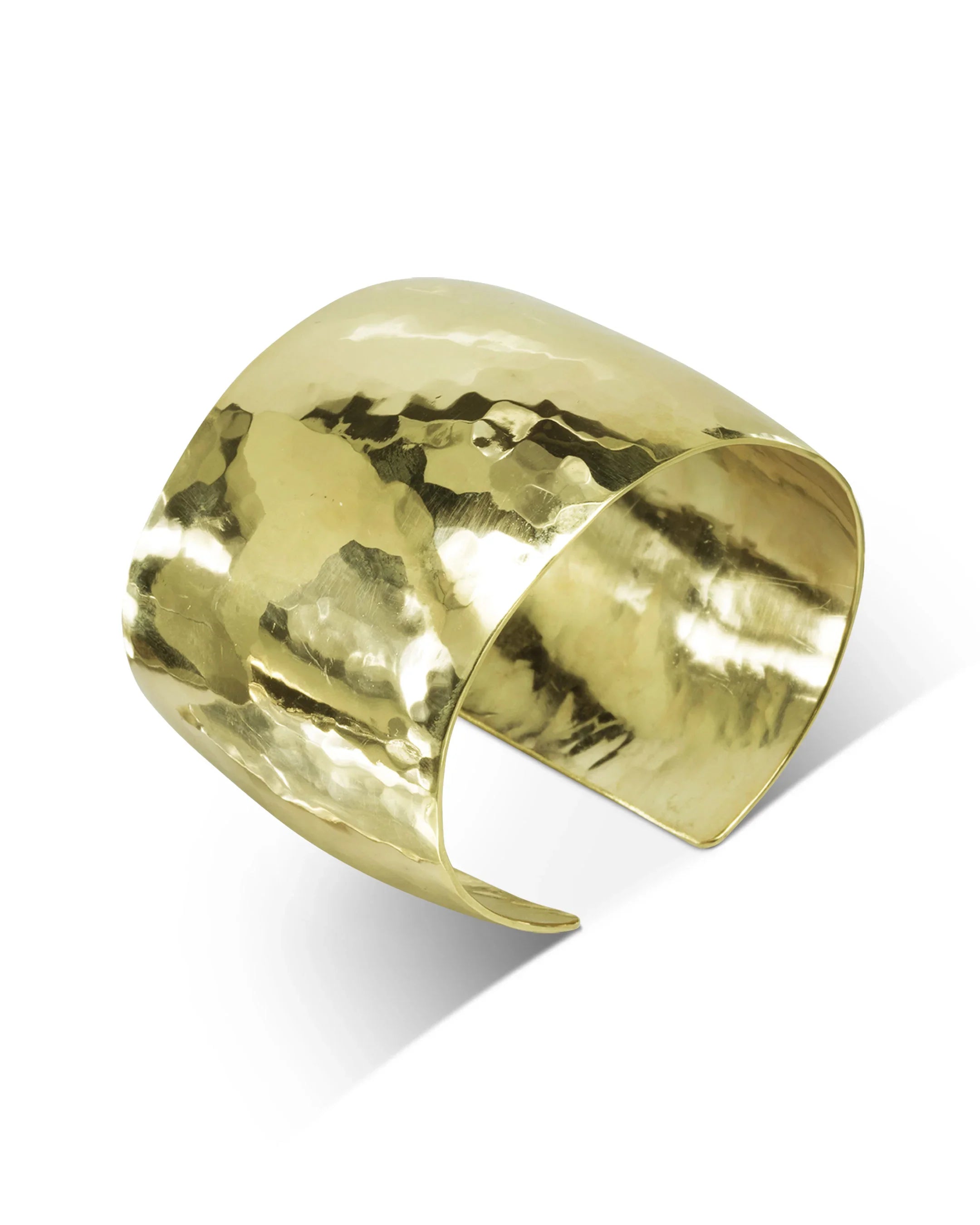 Handmade wide gold cuff bracelet with hammered texture on white background