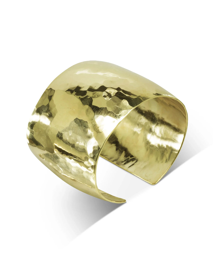 Handmade wide gold cuff bracelet with hammered texture on white background