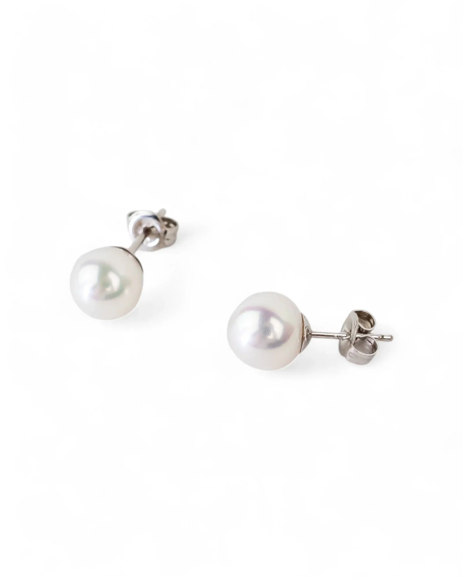 Gold stud earrings with classic round white pearls.
