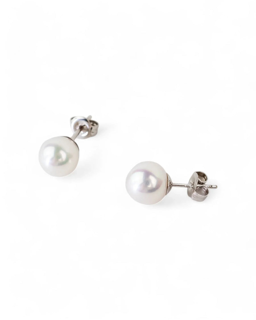 Gold stud earrings with classic round white pearls.