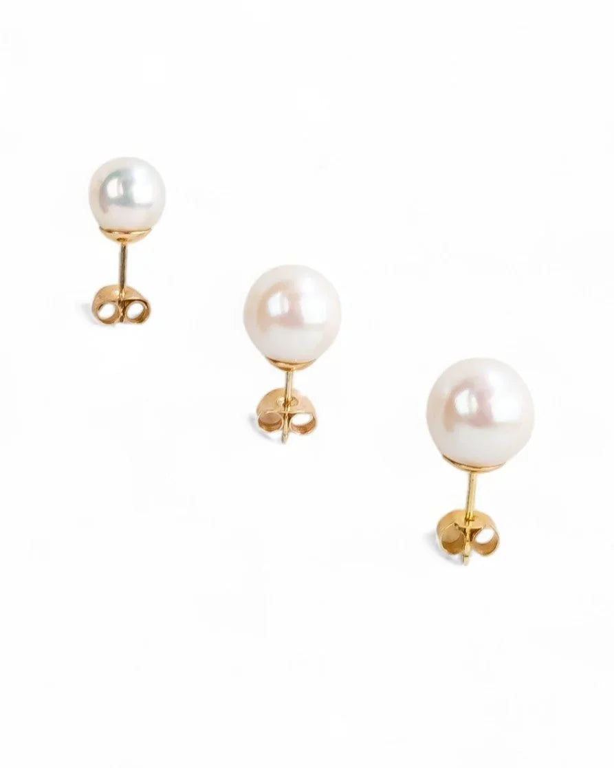 Three classic round pearl gold stud earrings.