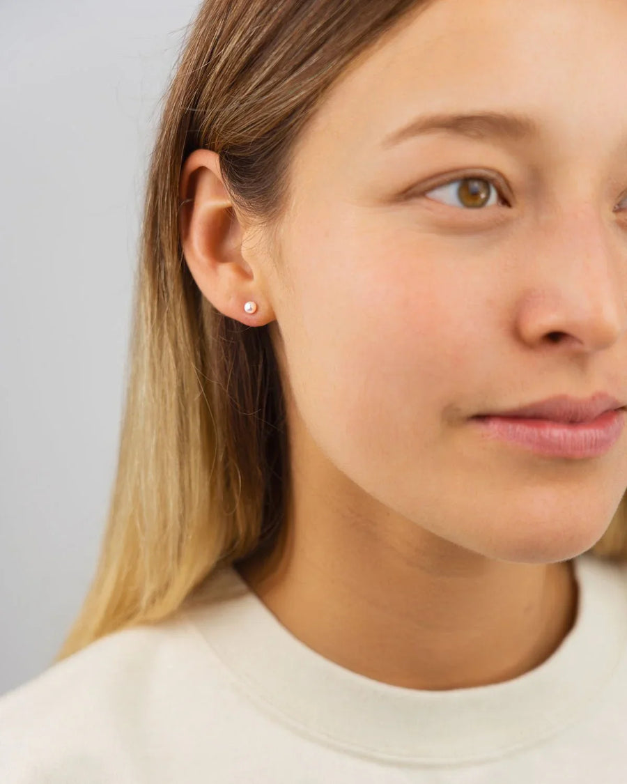 9ct white gold 4mm Akoya pearl round stud earring on a woman's ear.