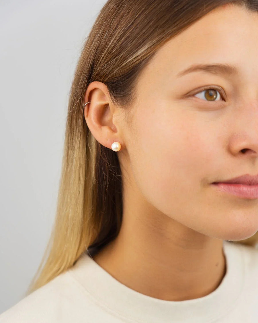 9ct white gold 5mm Akoya pearl stud earring on a woman's ear.