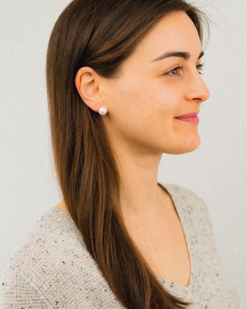 Woman wearing a 9ct white gold 8mm freshwater pearl stud earring.