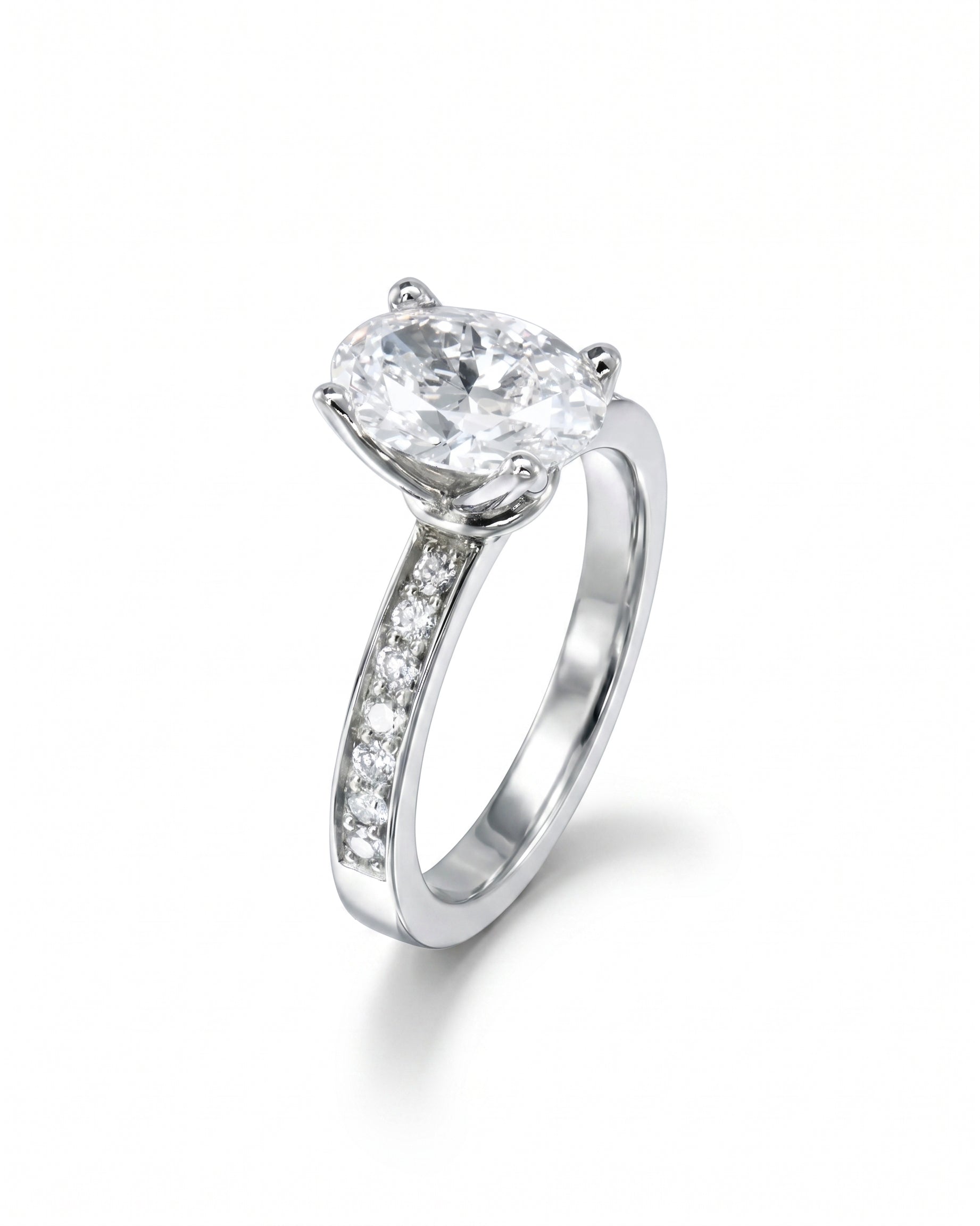 Silver claw oval diamond engagement ring with pavé set diamond band.