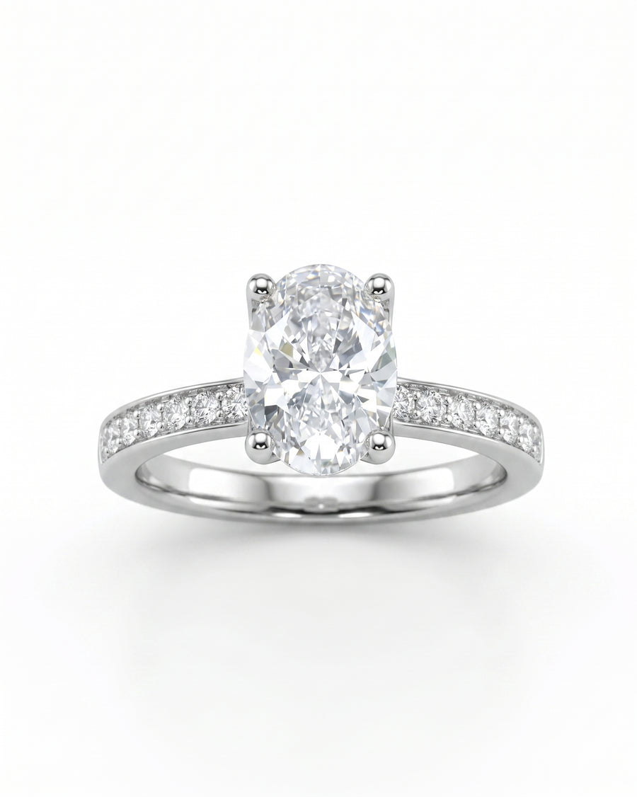 Silver claw oval diamond engagement ring with pavé set diamond band.
