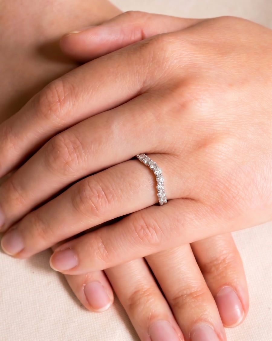 Claw round cut diamond shaped wedding ring on a hand.