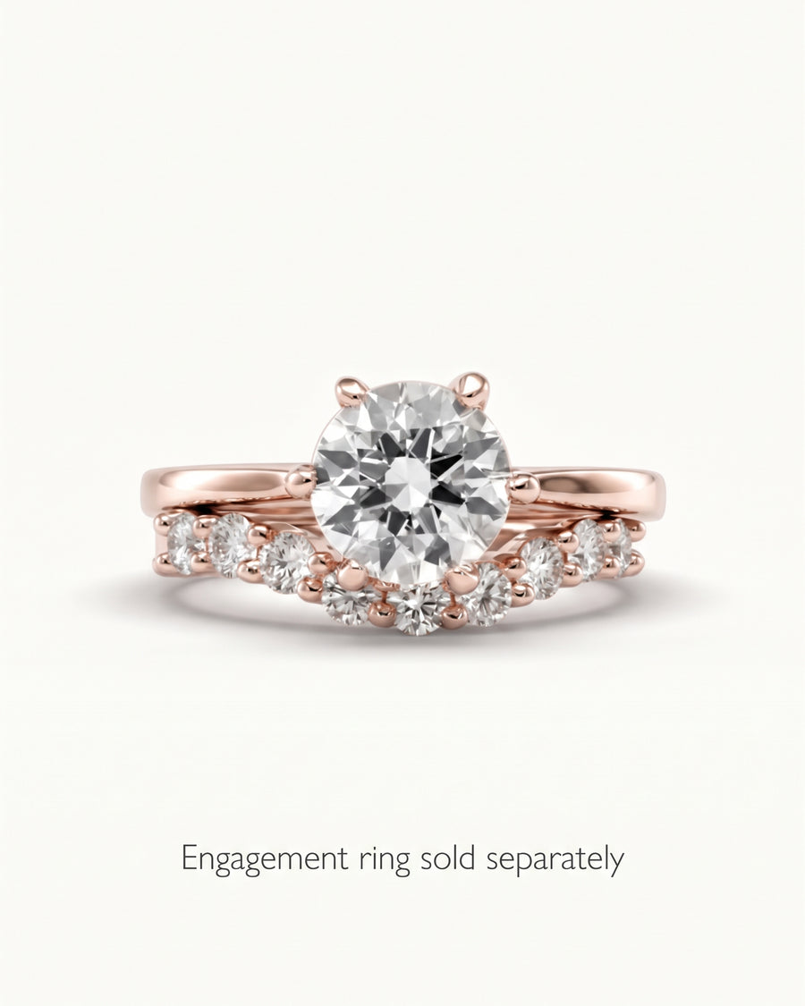 Rose gold wedding band with a curved design and round cut diamonds, set against a plain white background.