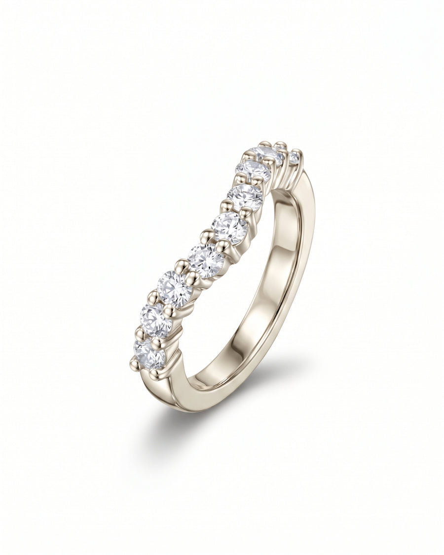 Curved silver wedding ring featuring a row of round cut diamonds in claw settings.
