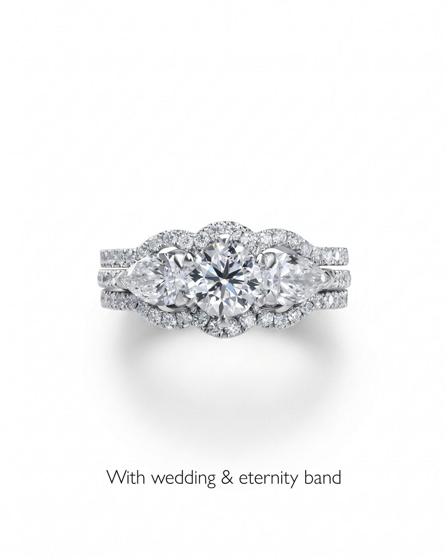 Platinum trilogy engagement ring with round and pear cut diamonds, with wedding and eternity bands.