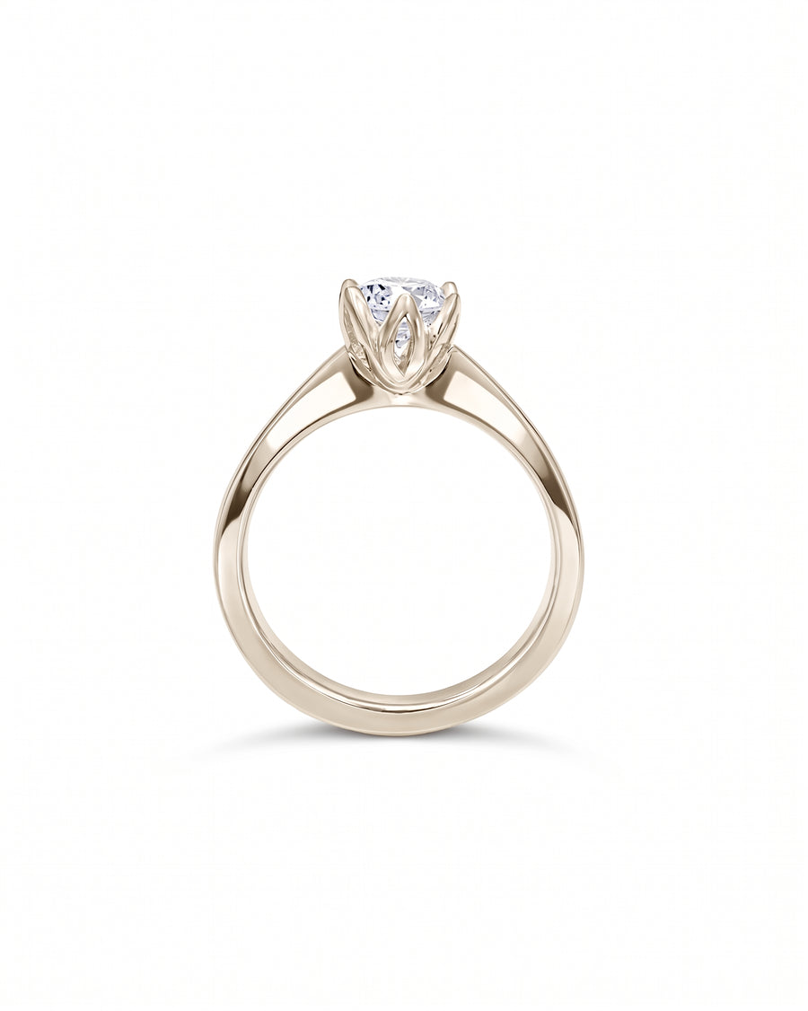 Round diamond engagement ring in polished platinum with a six-prong claw setting on a plain band.
