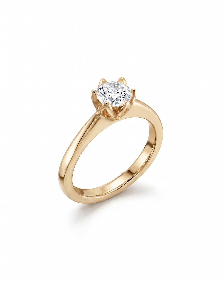 Round brilliant cut diamond engagement ring in a yellow gold six-prong claw setting.