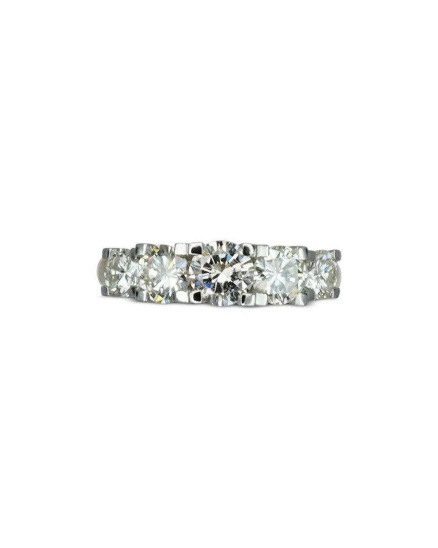 White gold eternity ring with five claw-set round diamonds.