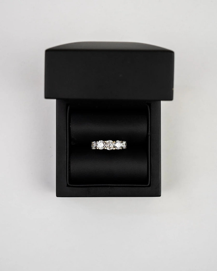 Silver claw set five diamond eternity ring in a black box.