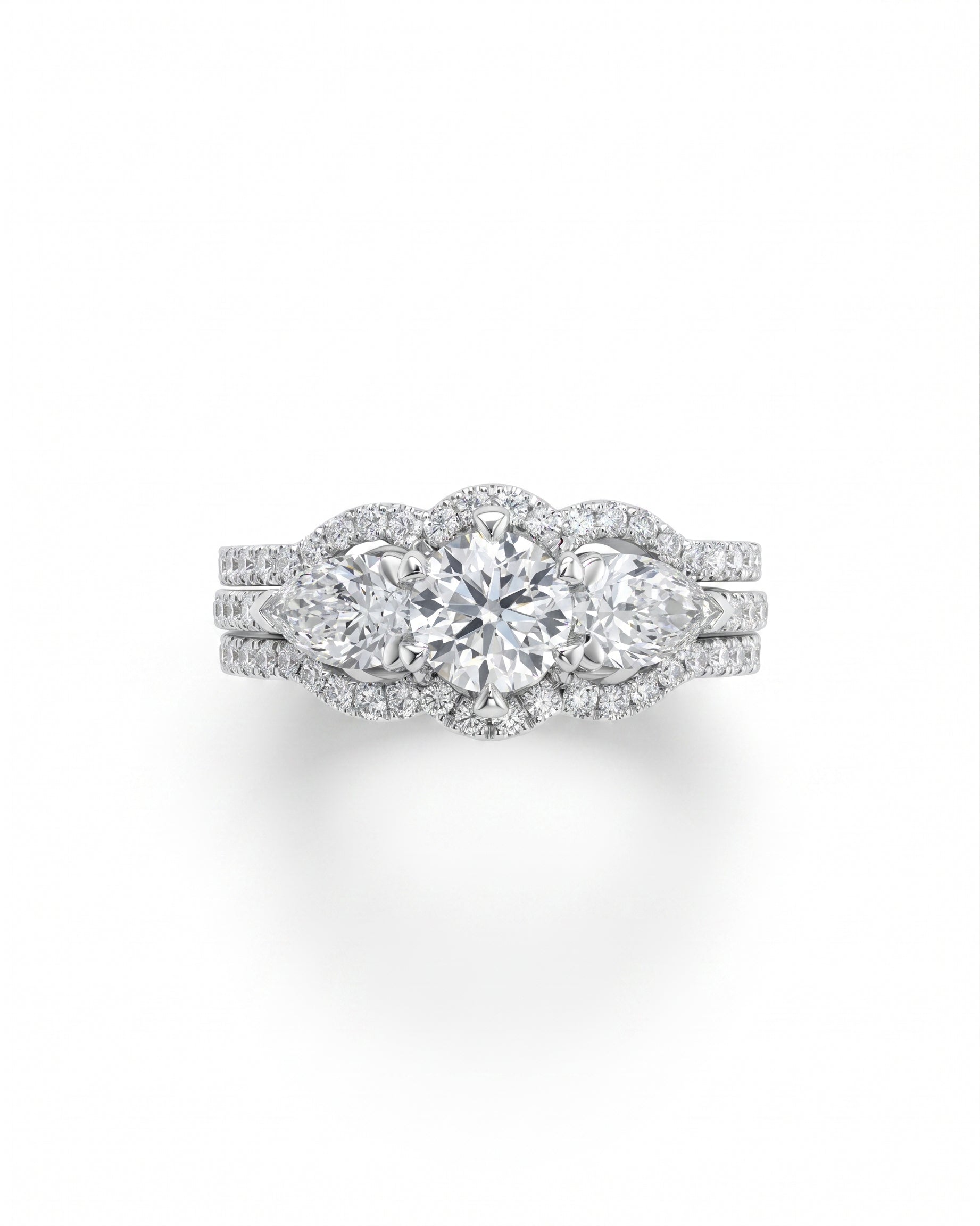 White gold trilogy ring set with round brilliant and pear shaped diamonds.
