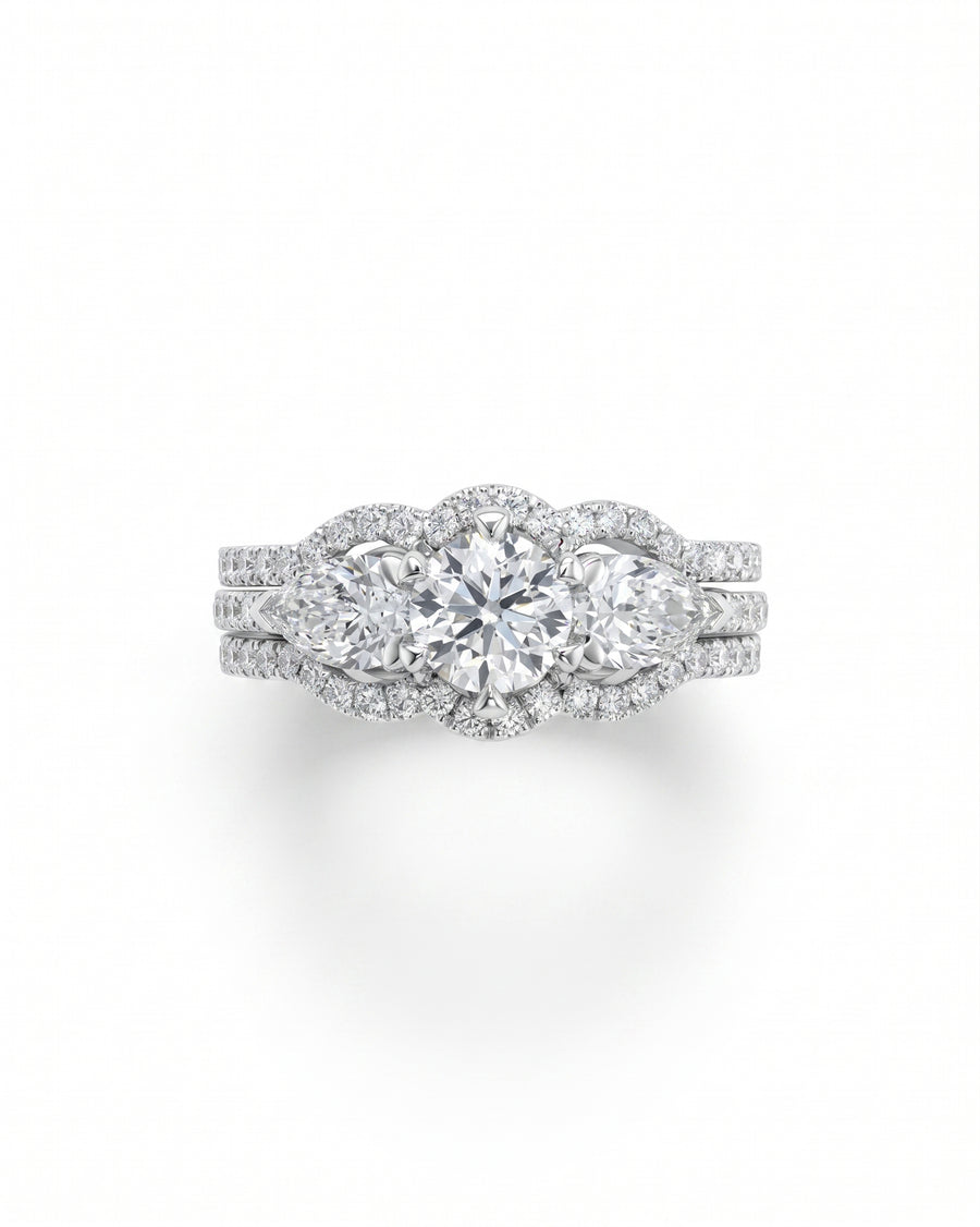 White gold trilogy ring set with round brilliant and pear shaped diamonds.