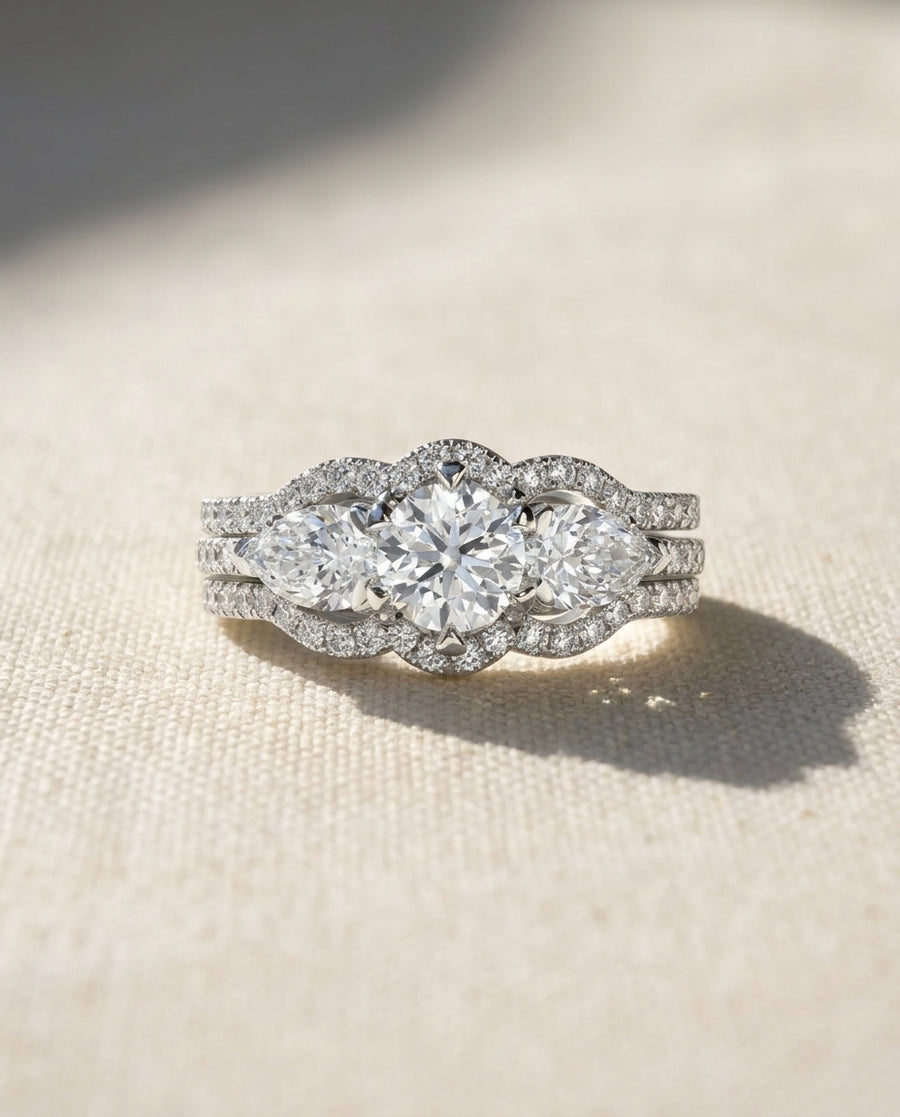 Platinum claw set round brilliant and pear shaped diamond trilogy ring set.