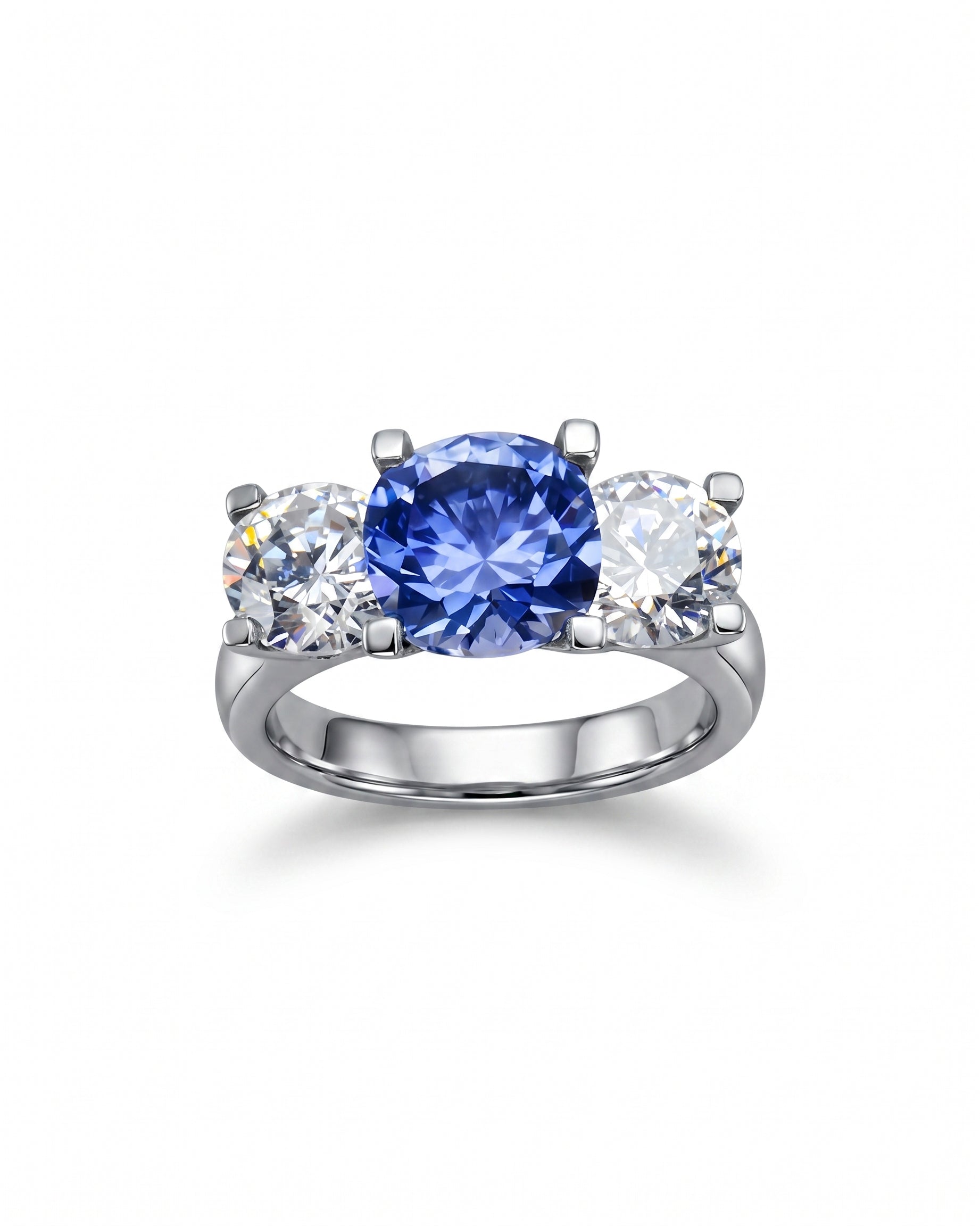 Platinum trilogy ring with a claw set blue sapphire and two round diamonds.