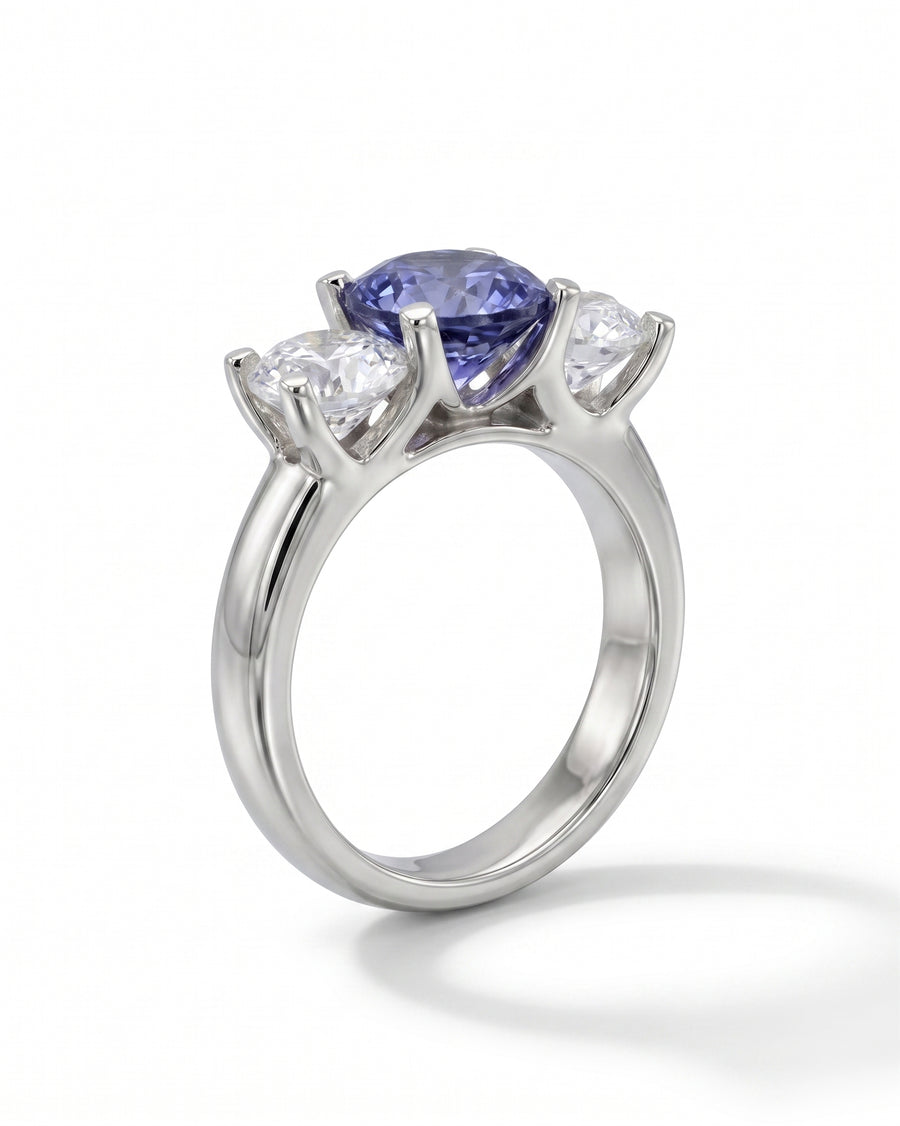 Platinum trilogy ring with a claw set sapphire and two diamonds.