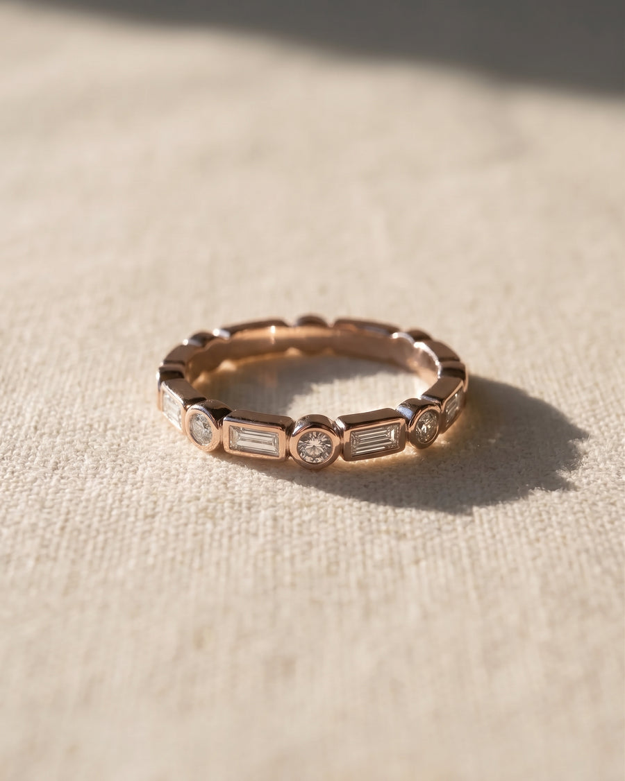 18ct rose gold half set eternity ring with alternating baguette and round diamonds.
