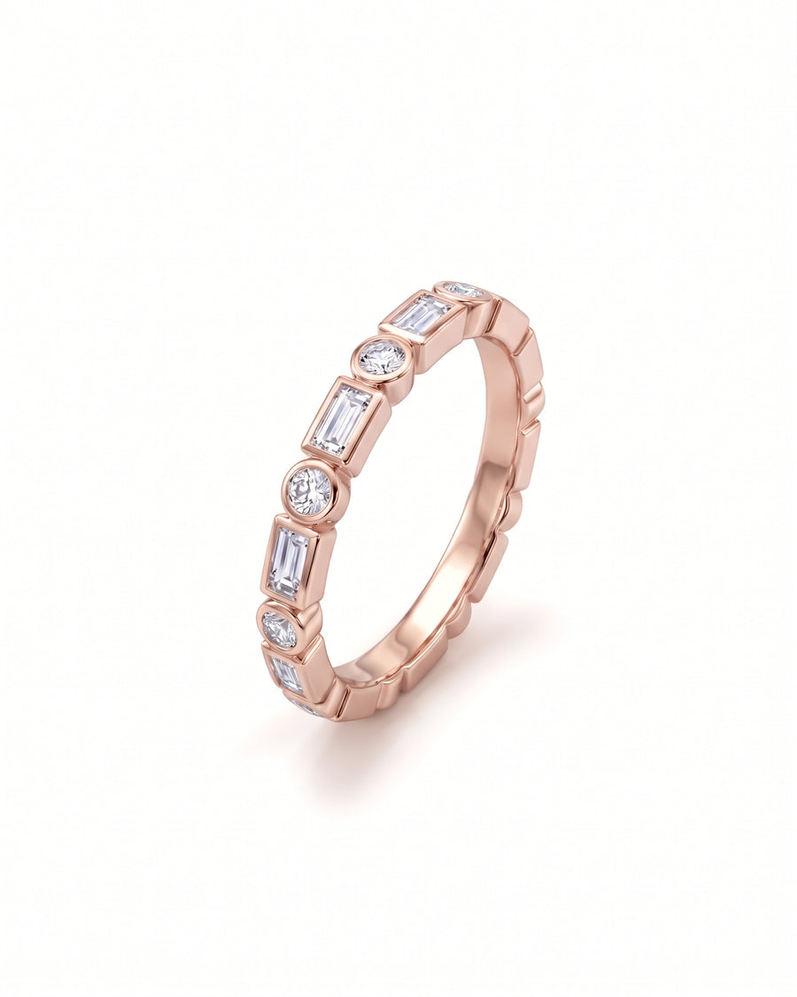 Rose gold ring featuring alternating baguette and round diamonds in a bezel setting.