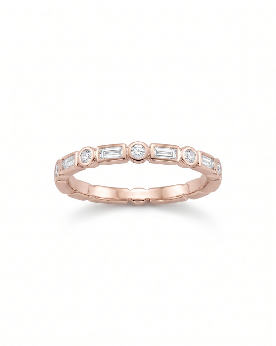 Rose gold ring featuring alternating baguette and round diamonds in a bezel setting.
