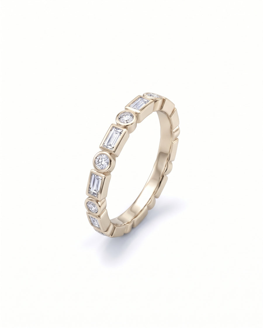 Gold ring featuring alternating baguette and round diamonds in a bezel setting.