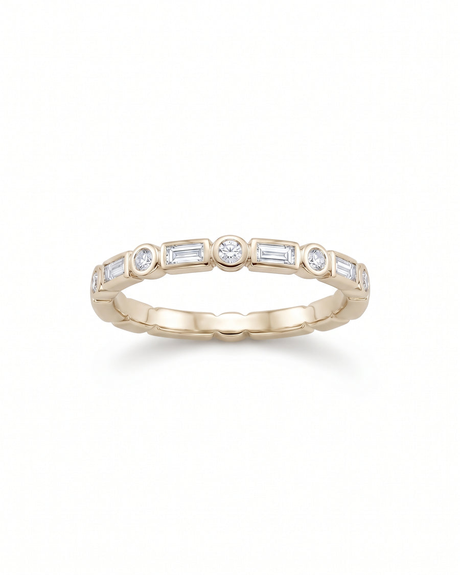 Gold band ring featuring alternating baguette and round diamonds in a bezel setting.