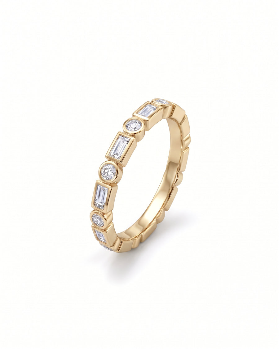 Gold ring featuring alternating round and baguette-cut diamonds in a bezel setting.