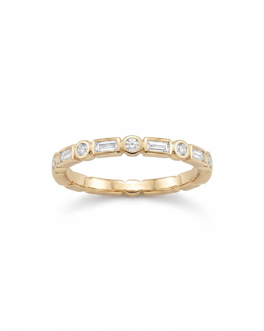 Gold ring featuring alternating baguette and round diamonds in a bezel setting.