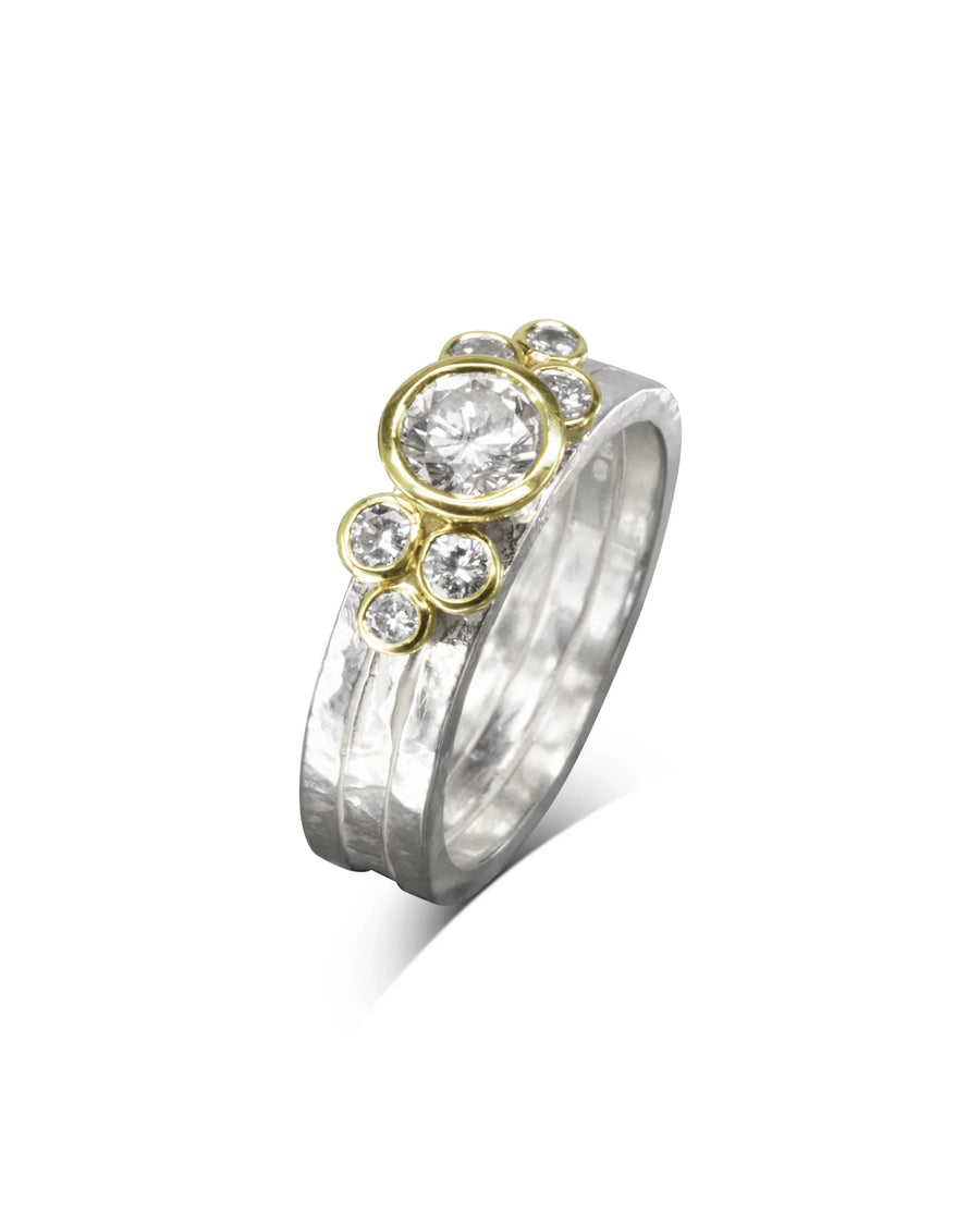 Silver rough hammered stacking rings with gold bezels and round diamonds.