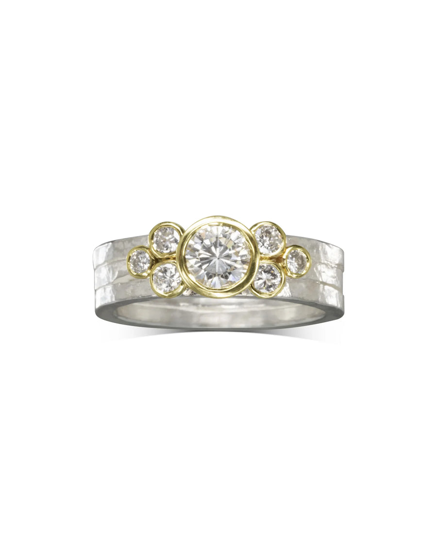 Silver and gold hammered ring with a large center diamond and smaller surrounding diamonds.