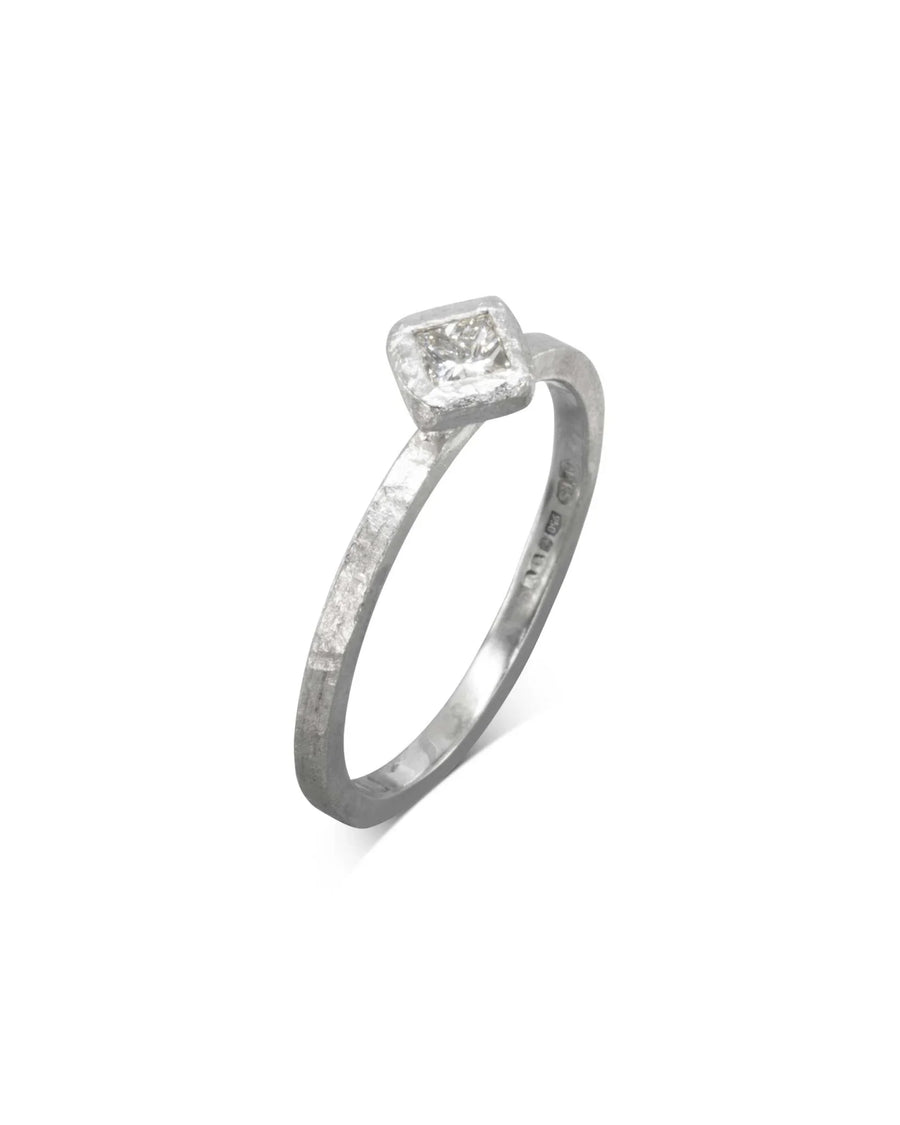 Silver rough hammered engagement ring with a square diamond.