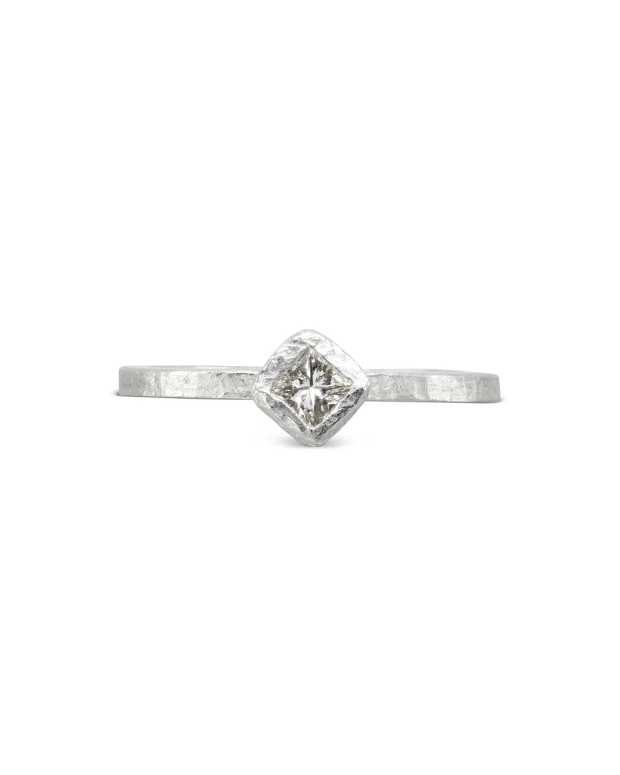 Silver rough hammered engagement ring with a square diamond.