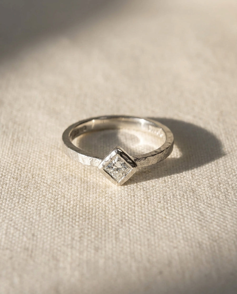 Platinum rough hammered engagement ring with a princess-cut diamond.