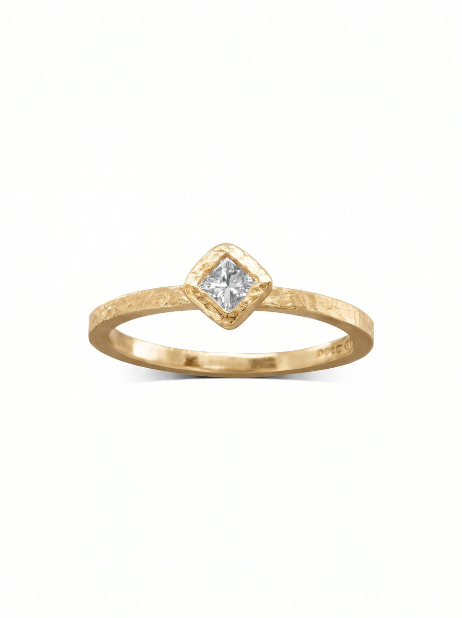 Gold engagement ring with a hammered texture and a square-cut diamond in a bezel setting.