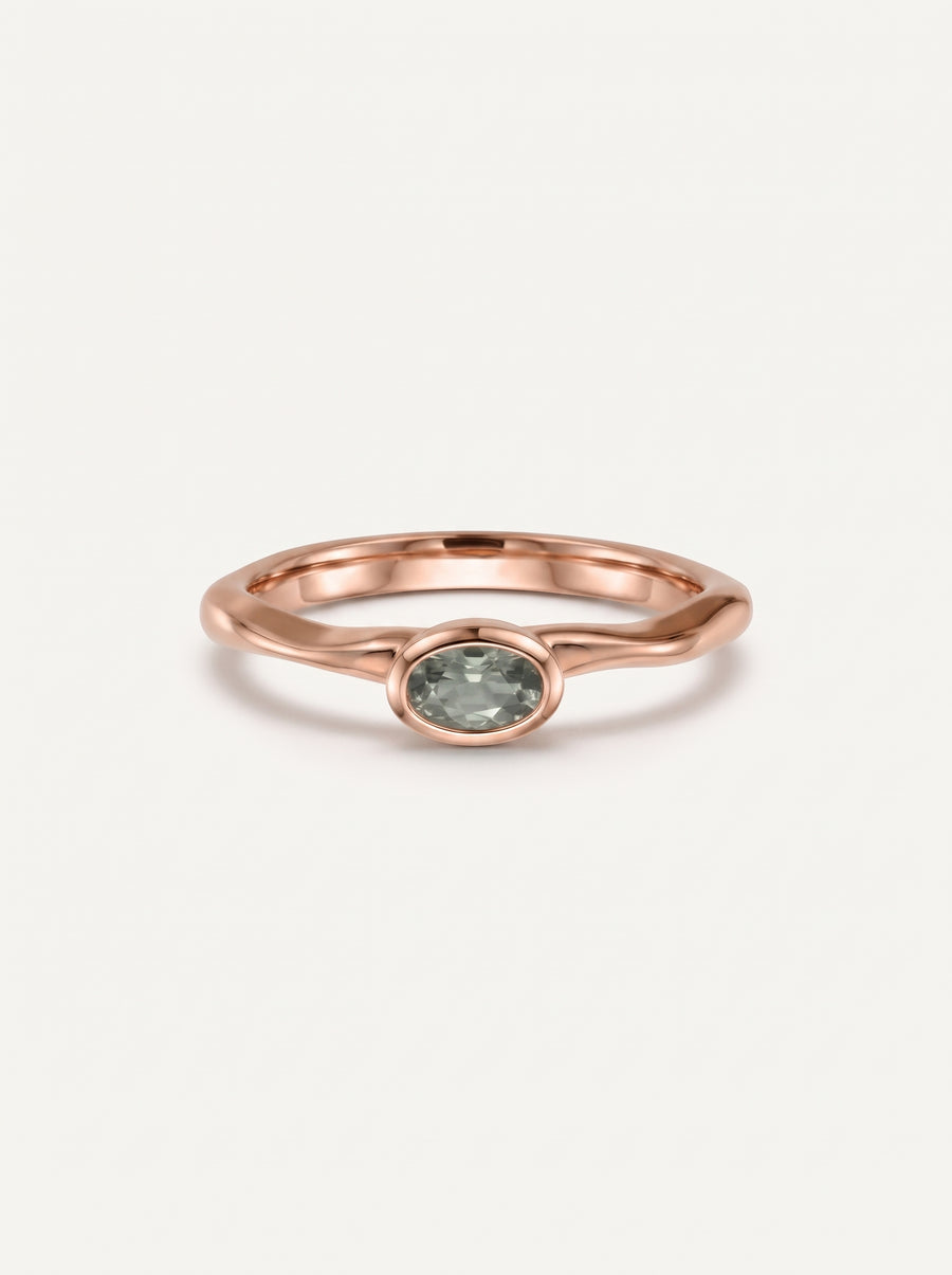 Dainty 18ct rose gold engagement ring featuring an oval green sapphire in a smooth bezel setting.