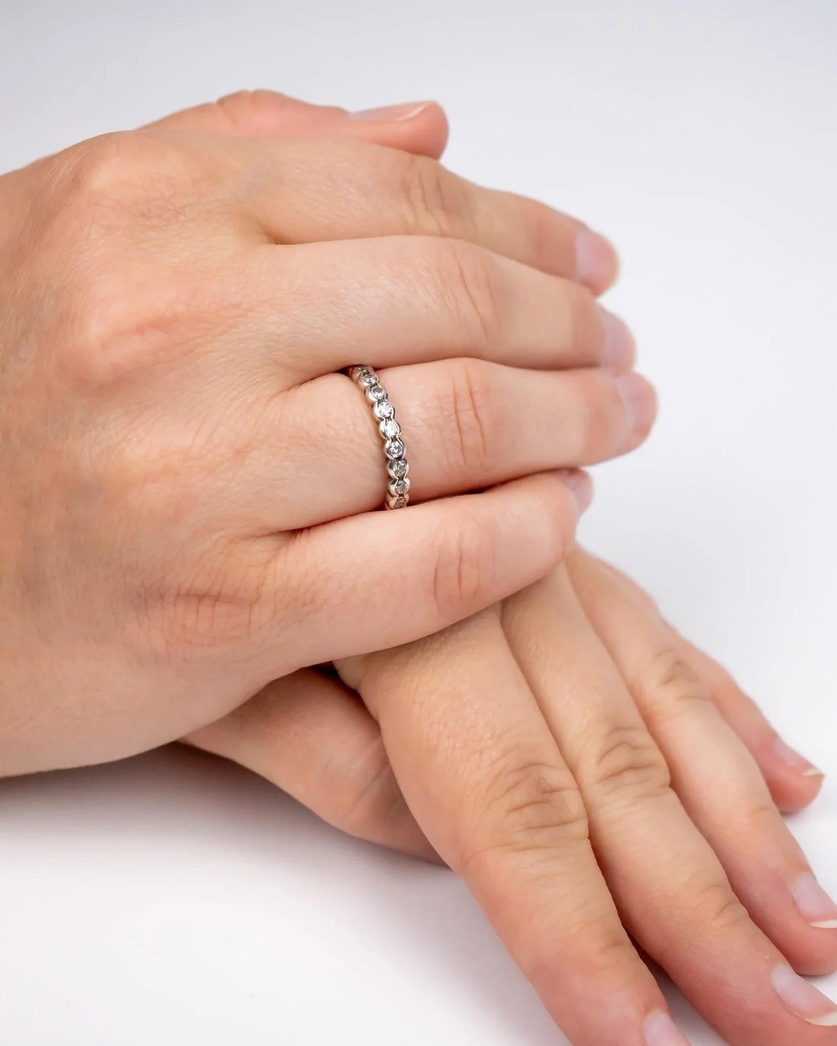 Delicate diamond eternity ring with scalloped edge on hand, handmade fine jewellery