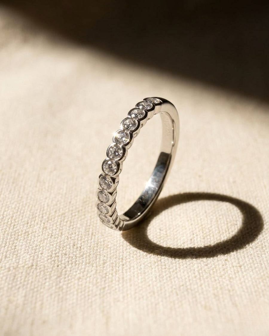 Platinum ring with a scalloped edge and diamonds.