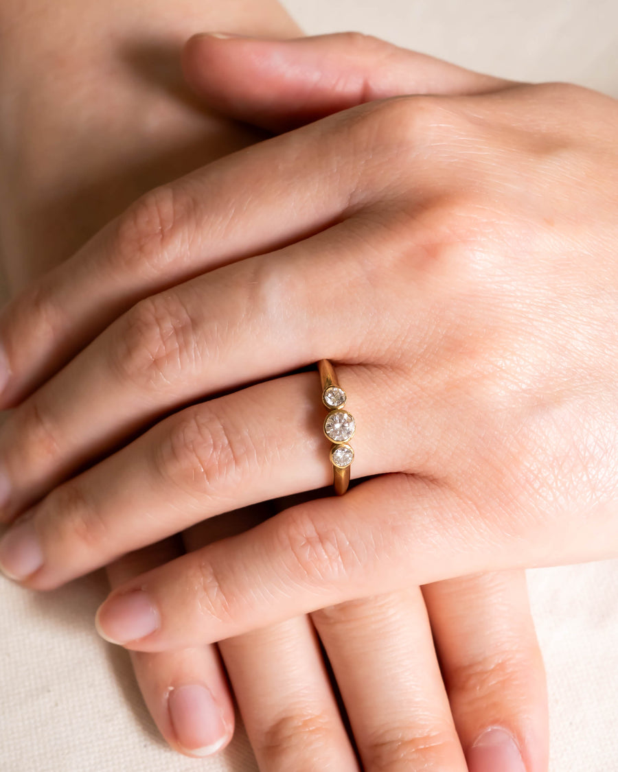 9ct gold trilogy diamond engagement ring on a hand.