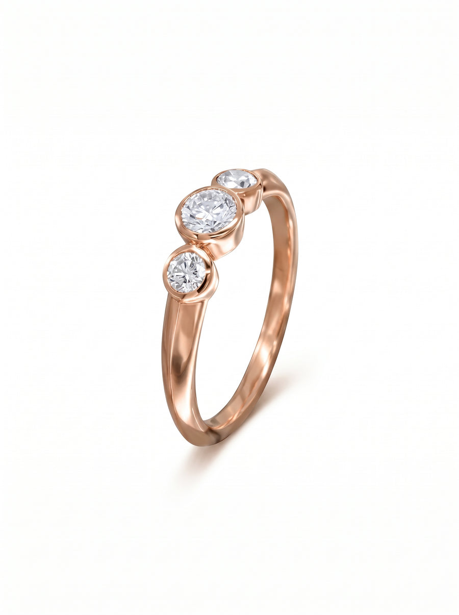 Trilogy engagement ring in 9ct rose gold featuring three bezel-set round diamonds on a polished band.