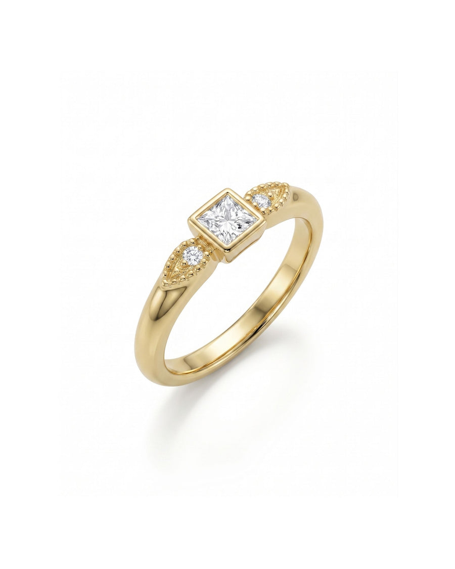 Gold engagement ring with a princess-cut diamond and two pear-shaped side diamonds.